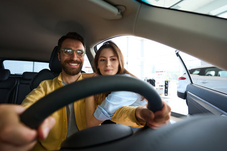Young couple choosing auto in car showroom
