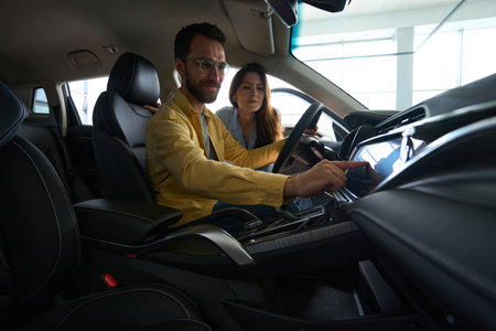 Young couple choosing auto in car showroom
