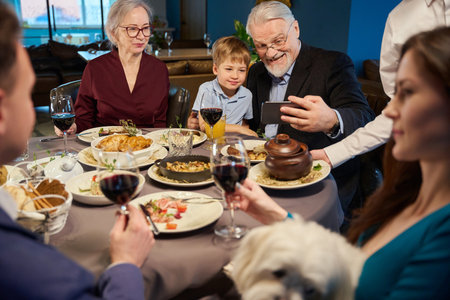Family celebrating New Year Eve making selfie on smartphoneの写真素材