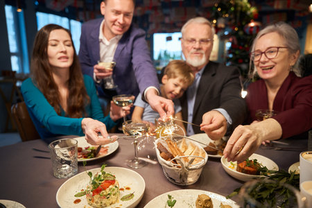 Excited family holding sparkling during New Year party in restaurant