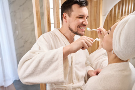Cheerful newlyweds doing their morning routine in the bathroomの写真素材