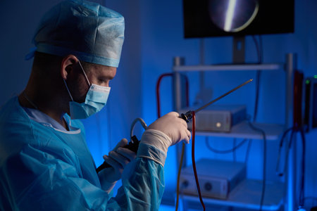 European male doctor preparing hysteroscope for surgery in clinicの写真素材