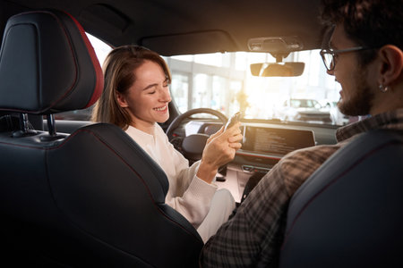 Woman and man buying new automobile holding keys smiling happily