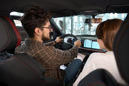 Woman and man sitting in front seats in new automobile buy modern model of car