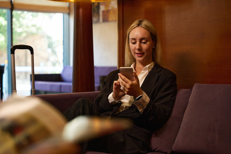 Close up photo of businesswoman sitting with smartphone in handsの写真素材
