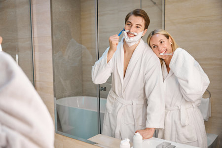 Happy couple in bathroom doing morning routine