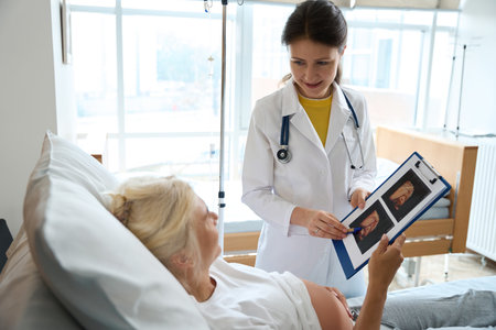 Nurse with ultrasound photo and pregnant woman looking at each otherの写真素材