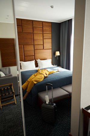Female in a yellow travel suit lies on large bed