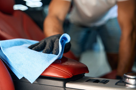 Master in protective gloves cleans a leather armrestの写真素材