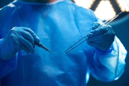 Unrecognizable professional surgeon holds medical equipment tweezers and scalpelの写真素材