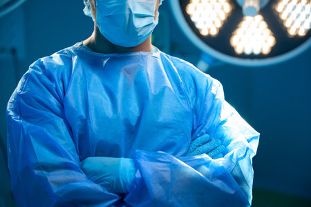 Unrecognizable man surgeon standing with arms crossed in operation theaterの写真素材