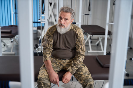 Bearded military man sitting in the gym of rehabilitation centerの写真素材