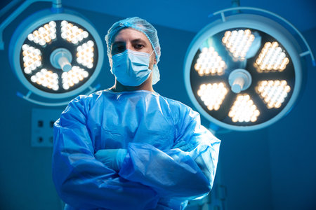 Confident man surgeon standing with arms crossed in operation theater