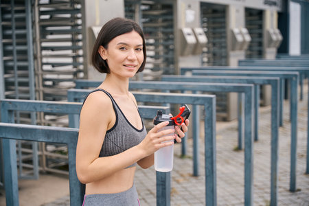 Strong female resting after run outside, drink water