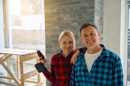 Cheerful lady and man standing near each other in room