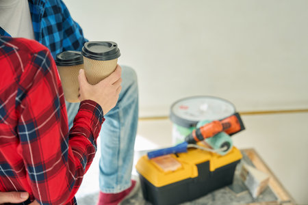 Couple hands holding coffee in ripple paper glassesの写真素材