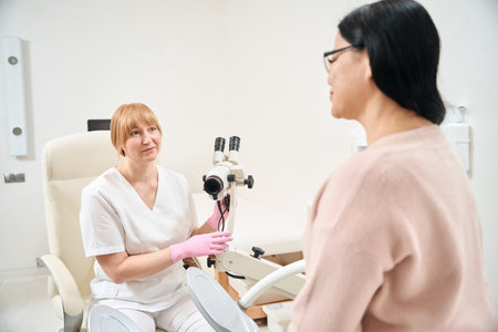 Gynecologist using microscope during pelvic exam for diagnosing any infections