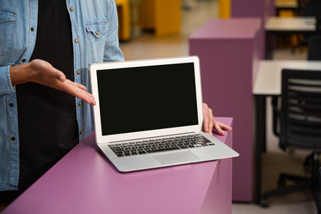 Male hand pointing at laptop which putting on cabinet