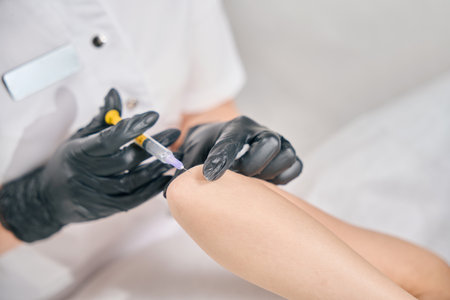 Close up cropped view of female beautician doing elbow beauty injection of womanの写真素材