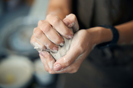 Unrecognizable woman holds clay preparing artisan for creating ceramics productsの写真素材