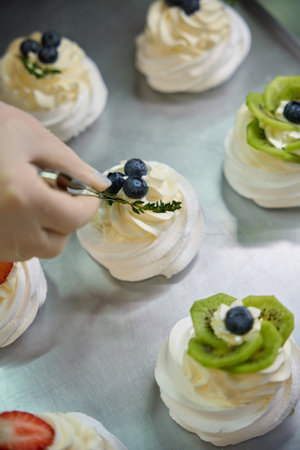 Baker adding some green on top of sweet and crispy dessertの写真素材