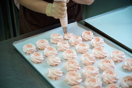 Woman cook pushing on pastry bag with sweet fruit mixture