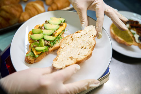 Close-up woman chef preparing tasty appetizer croissant with delicious fillingの写真素材