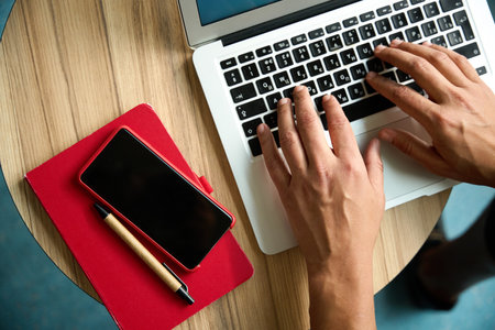Cropped picture of male hands typing on laptopの写真素材