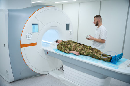 Radiographer preparing military patient for magnetic resonance imaging scan