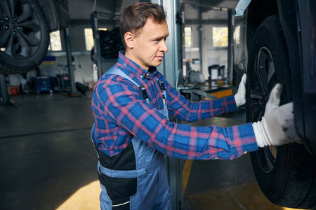 Engineer in tire fitting preparing for automobile repairの写真素材