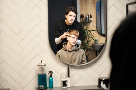 Experienced barber working in contemporary hairdressing salonの写真素材