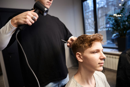 Experienced barber serving visitor in modern barbershop