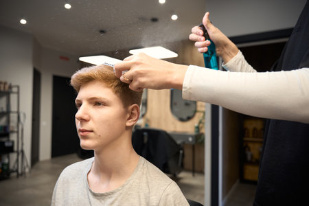 Experienced barber serving visitor in contemporary barbershopの写真素材