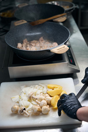 Woman cuts vegetables and mushrooms on a cutting boardの写真素材