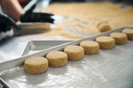 Kitchen employee forms cutlets in breadcrumbs