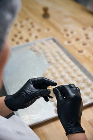 Woman makes dumplings on a large wooden table