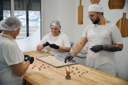 People make dumplings on a large wooden tableの写真素材
