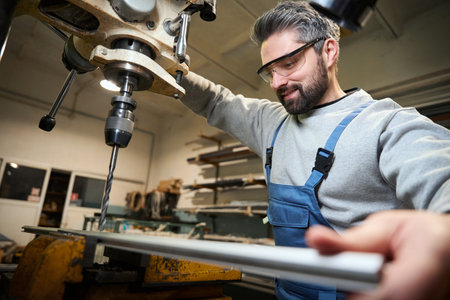 Professional drills hole into an aluminum profile on modern machine