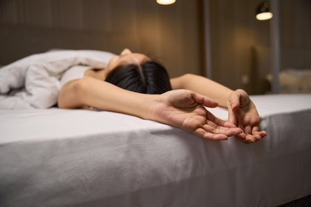 Brunette woman enjoying awakening on comfortable bed with orthopedic mattressの写真素材