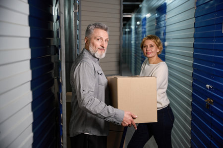 Portrait of couple with boxes in warehouse