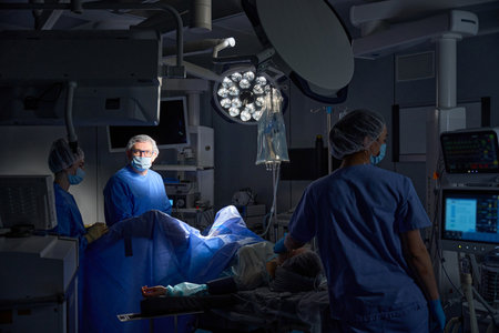 Group of surgeons in operating room with surgical laparoscopy equipment