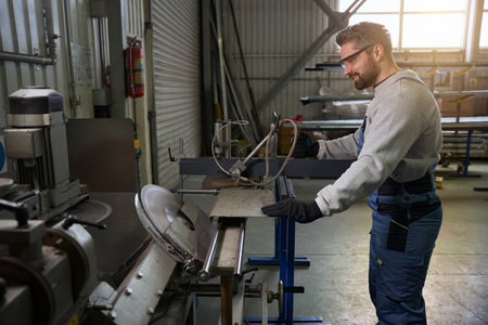Professional cuts an aluminum profile in a window production