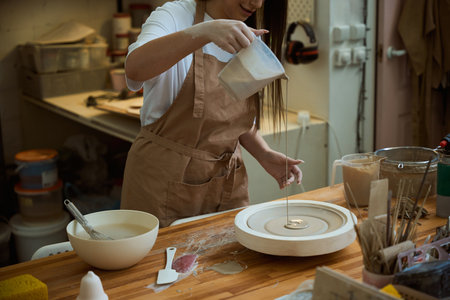 Female ceramist creating ceramic products from clay in workshop