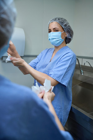 Two female surgeon doctors wash their hands before the operationの写真素材