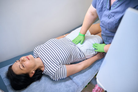 Therapist examines the patients lymph nodes at the receptionの写真素材
