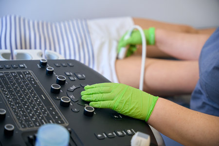 Specialist in protective gloves makes ultrasound diagnosis of patients legsの写真素材