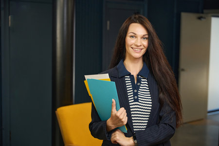 Woman in a stylish jacket stands in the corridorの写真素材