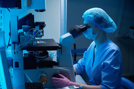 Embryologist operating in lab near a cryopreservation system screen