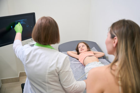 Doctor explaining ultrasound results to mother and childの写真素材