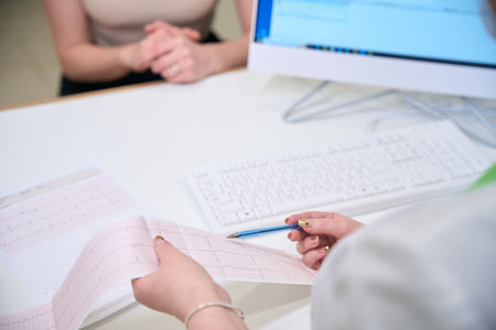 Doctor reviewing medical results with a patient at a deskの写真素材